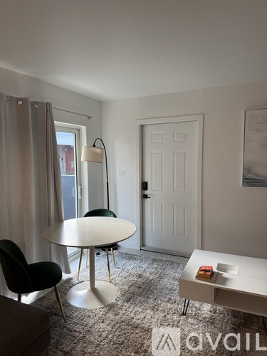 A living room with a white table and black chairs.