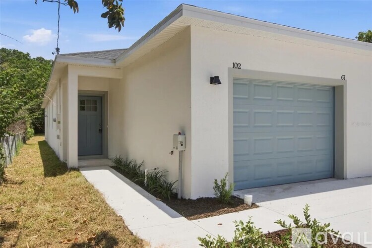A small white house with a blue garage door.