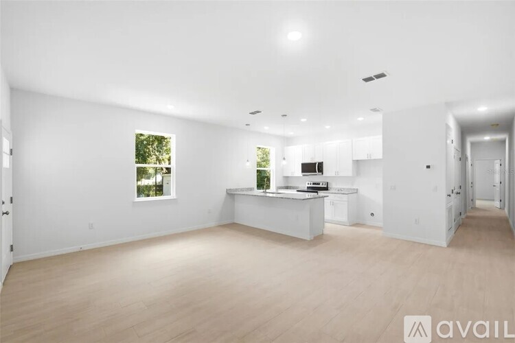 A spacious, empty room with a window and a counter in the background.