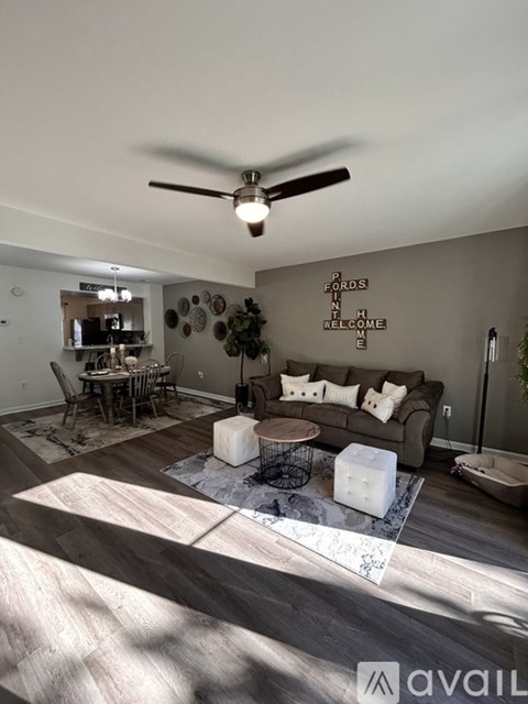 A living room with a couch, coffee table, and a ceiling fan.