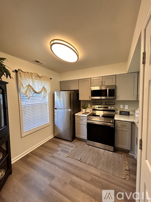 A kitchen with a refrigerator, oven, and microwave.