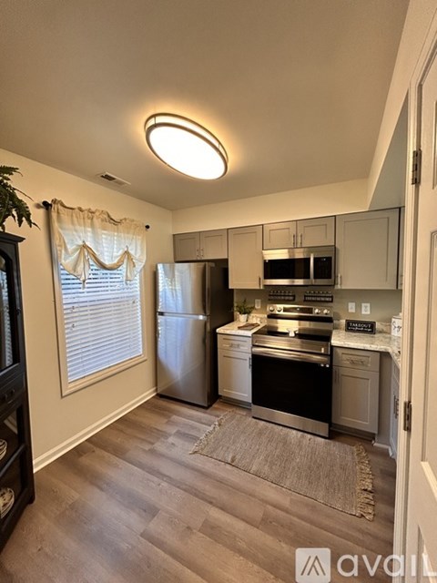 A kitchen with a refrigerator, oven, and microwave.