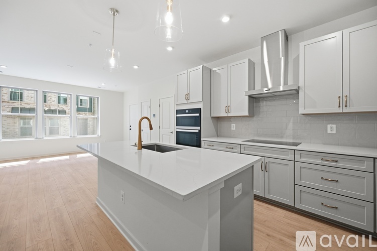 A modern kitchen with a large island and stainless steel appliances.
