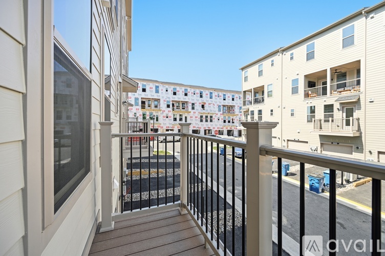 A balcony overlooks a parking lot and other buildings.