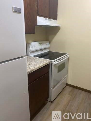 A kitchen with a white fridge, stove and oven.