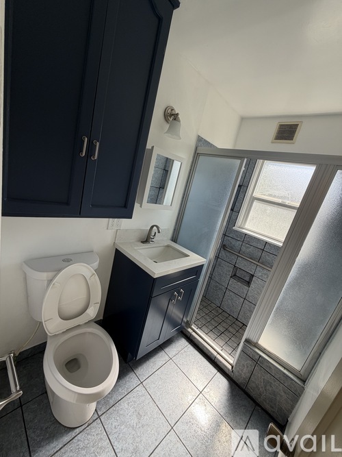 A bathroom with a toilet, sink, and shower.