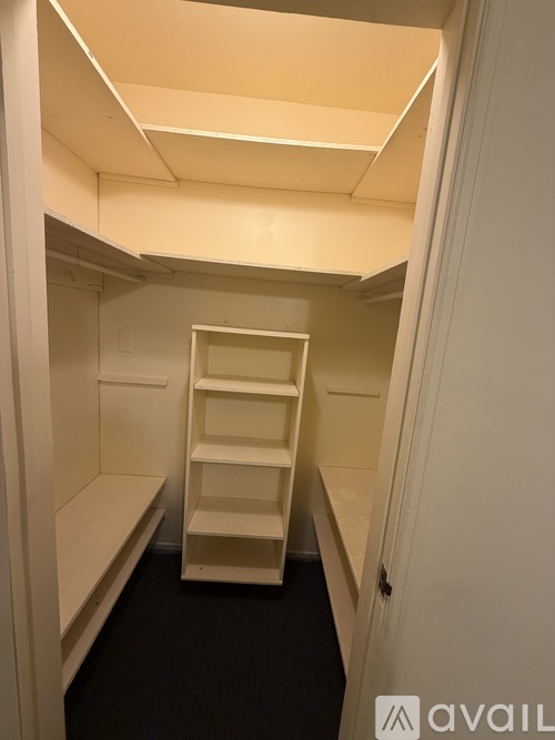 A white ladder is in a small, empty room.