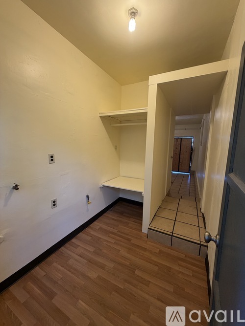 A room with wooden flooring and white walls.