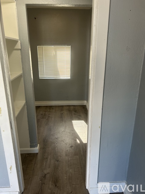 A room with a window and wooden flooring.