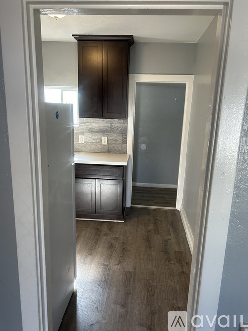 A kitchen with wooden cabinets and a refrigerator.