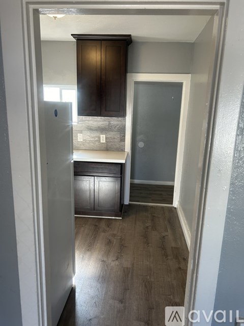 A kitchen with wooden cabinets and a refrigerator.