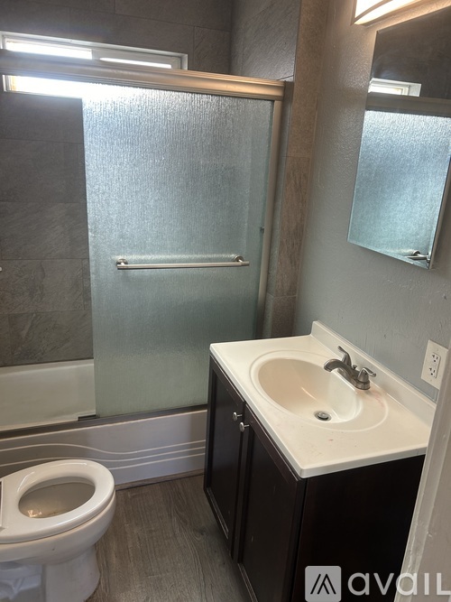 A bathroom with a toilet, sink, and shower.