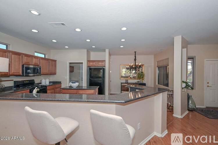 A kitchen with white chairs and a counter.