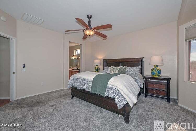 A bedroom with a bed, nightstand, and a ceiling fan.