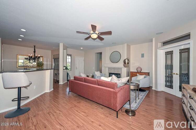 A living room with a red couch and a ceiling fan.
