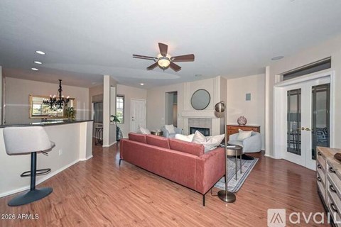 A living room with a red couch and a ceiling fan.