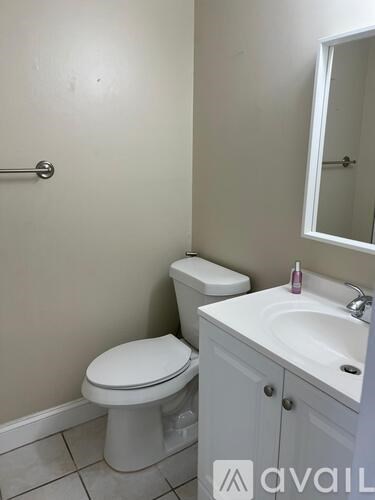 A white toilet sits next to a sink in a small bathroom.