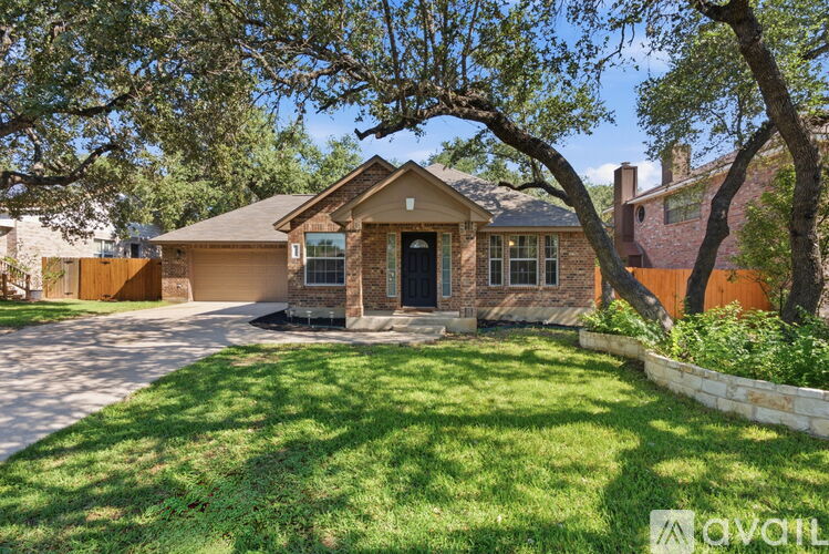 A house with a brown front door and a tree in front of it.