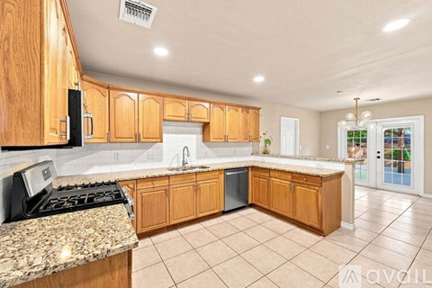 A kitchen with wooden cabinets and granite countertops.