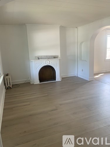 A room with a fireplace and wooden floors.
