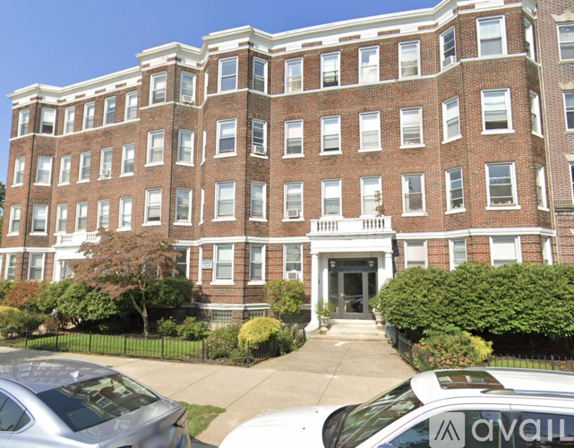 A large red brick building with a black fence in front.