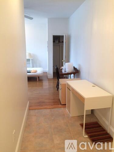 A room with a desk and a chair in it.