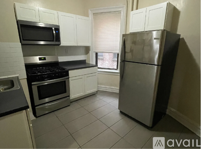 A kitchen with a refrigerator, stove, and microwave.