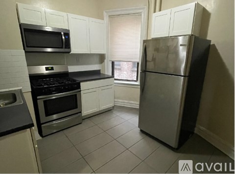 A kitchen with a refrigerator, stove, and microwave.
