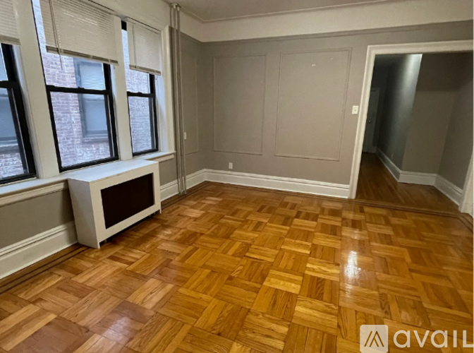 A room with wooden flooring and a window seat.