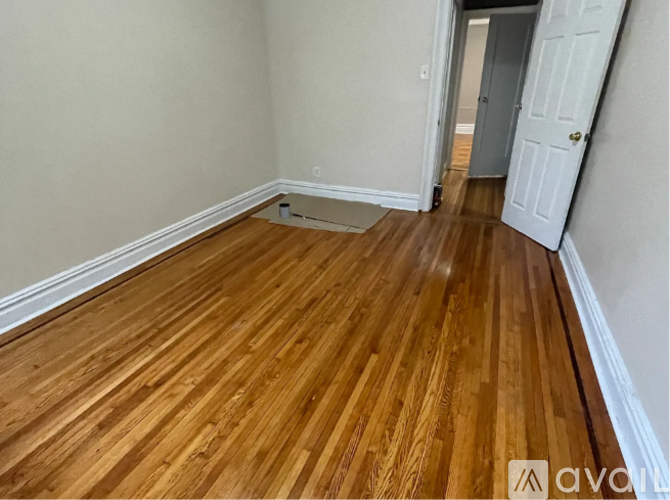 A room with wooden flooring and a white door.