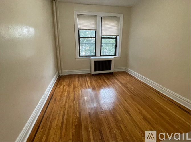 A room with wooden floors and two windows.