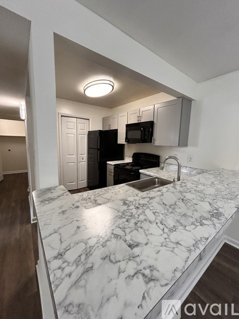 A kitchen with a marble countertop and stainless steel appliances.