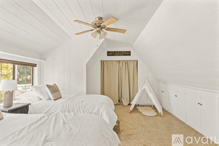 A bedroom with two beds and a ceiling fan.