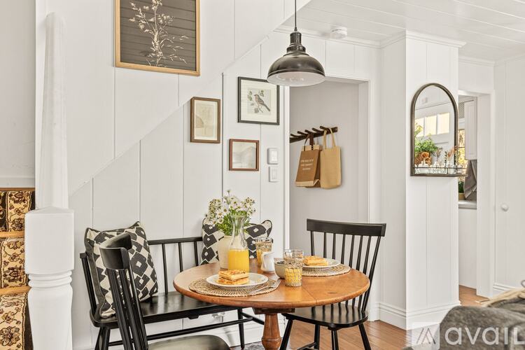 A dining room with a wooden table and chairs.