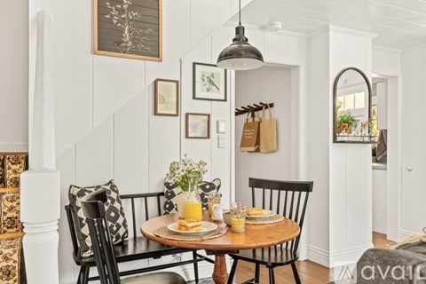 A dining room with a wooden table and chairs.