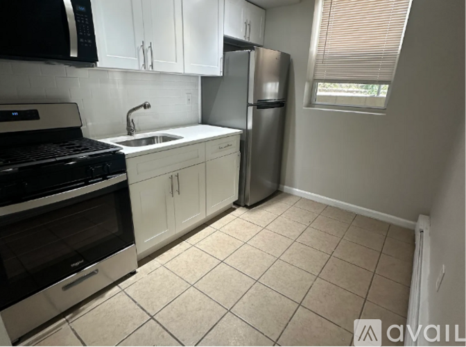 A kitchen with white cabinets and a black stove top oven.