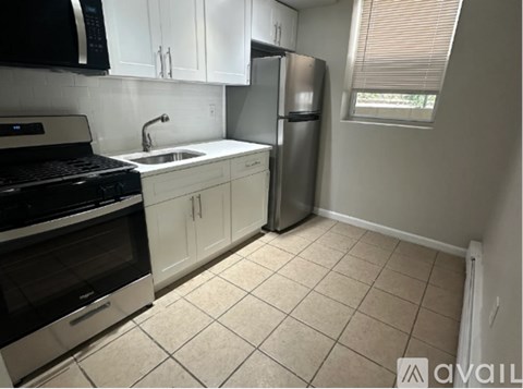 A kitchen with white cabinets and a black stove top oven.