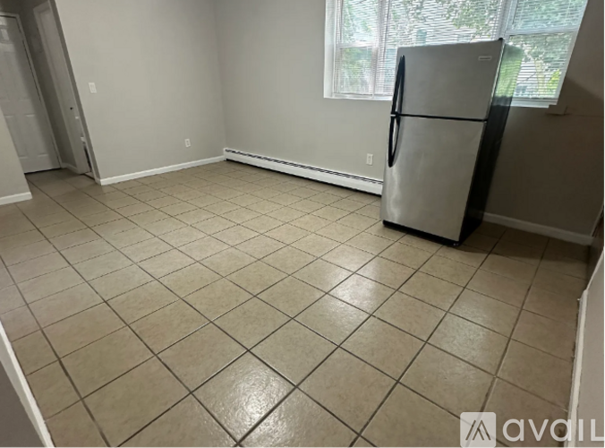 A kitchen with a fridge and tiled floor.