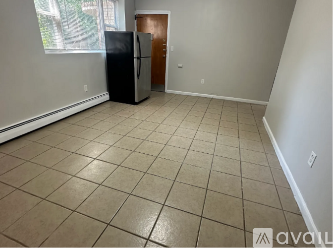 A kitchen with a black fridge and brown door.