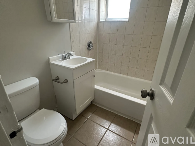 A white bathroom with a toilet, sink, and bathtub.