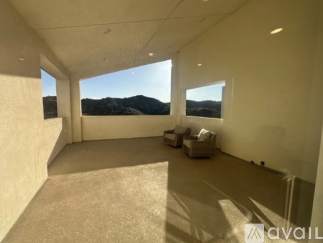 A spacious room with a view of the mountains outside the windows.