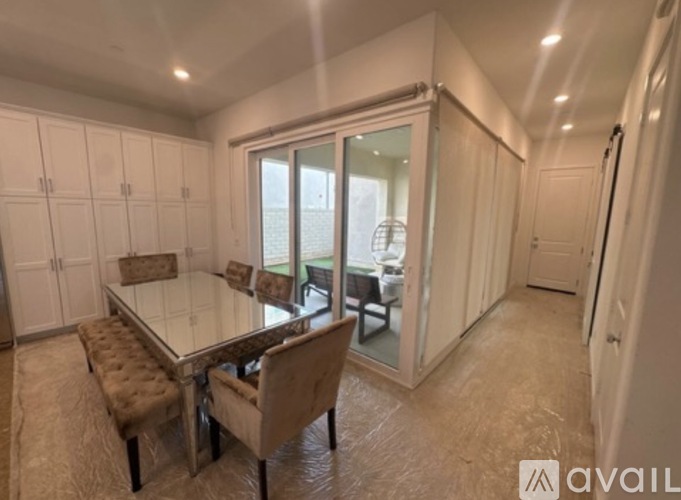 A dining area with a glass table and chairs.