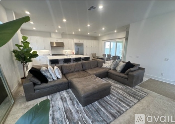 A living room with a grey couch and a rug.