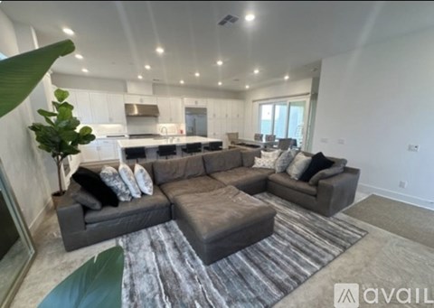 A living room with a grey couch and a rug.