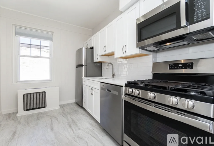 A kitchen with white cabinets and stainless steel appliances.