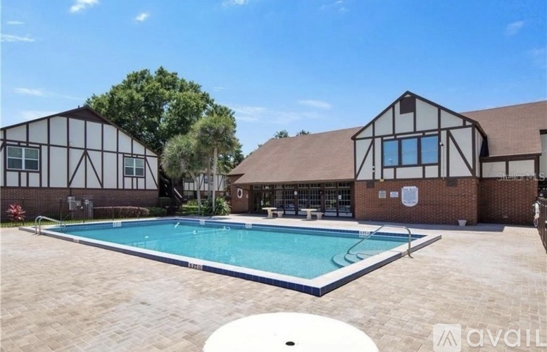 A pool in front of a building with a white and black exterior.
