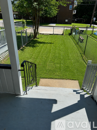 A small, fenced-in yard with a concrete walkway.