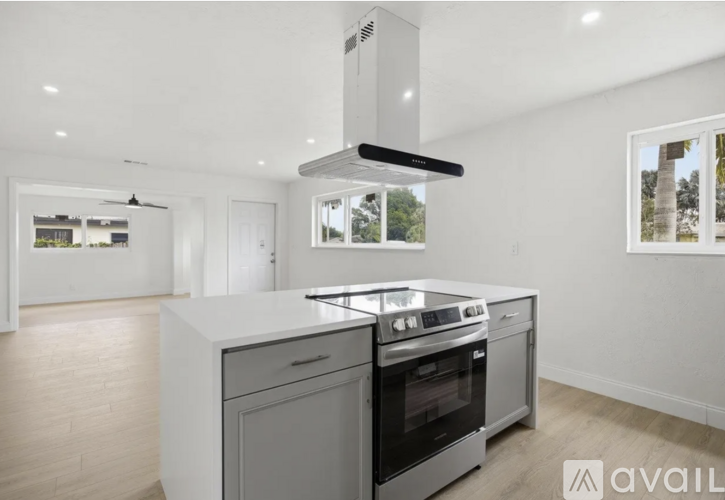 A modern kitchen with a stove top oven and a range hood.