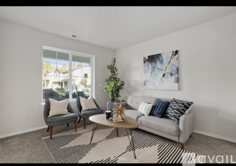 A living room with a grey couch, a coffee table, and a painting on the wall.