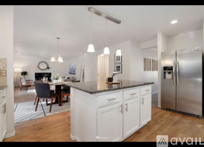 A modern kitchen with white cabinets and a large island.